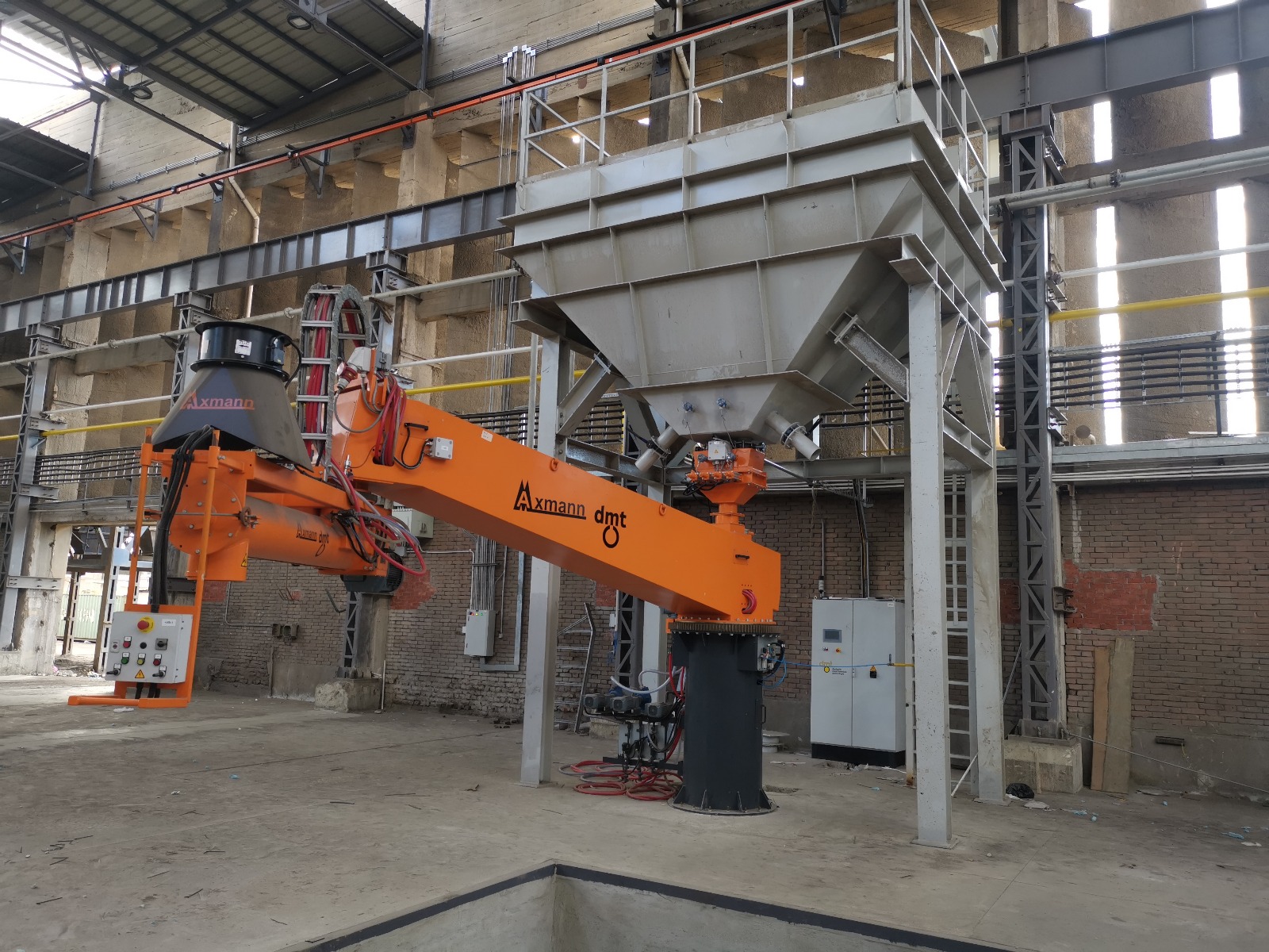 Axmann continuous arm mixer in action with overhead sand silo, No-Bake foundry line